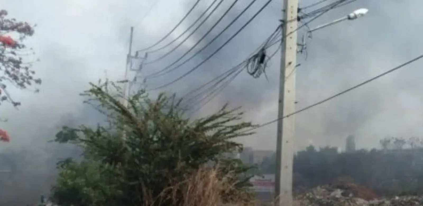 Feuerwehrleute bekämpfen in Jomtien, Pattaya, einen Grasbrand bei starkem Wind